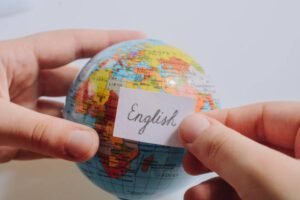 Hand holding notepaper with English wording on model globe